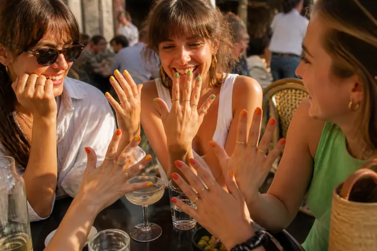 Des jeunes femmes françaises à Paris affichent des manucures colorées aux teintes vives et audacieuses pour l'été.