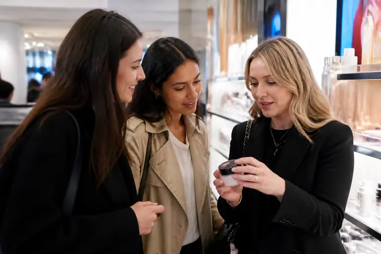Trois femmes amigas choisissent des produits de beauté dans un grand magasin français, un achat en toute confiance.