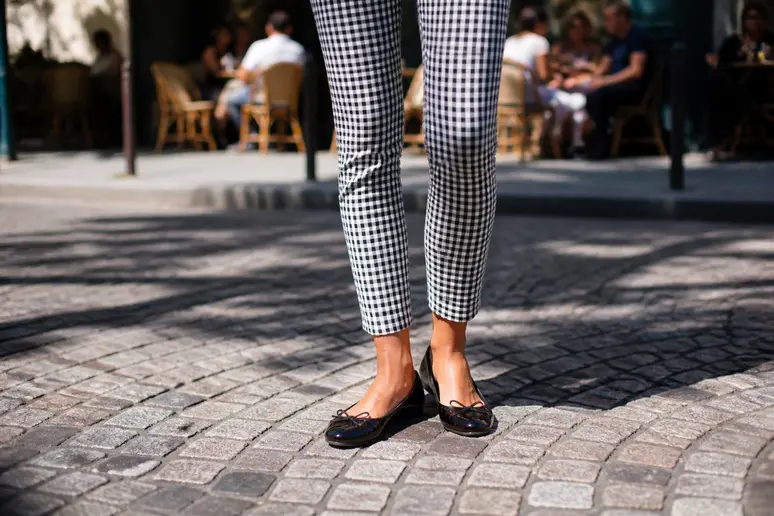 Zoom sur un pantalon carotte imprimé vichy, essentiel pour capter l'esprit guinguette et le charme rétro.