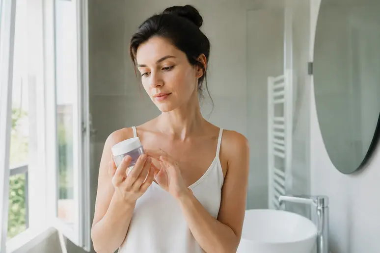 Une jeune femme réfléchit avec une crème Q+A, avis sur le produit, approche naturelle de beauté