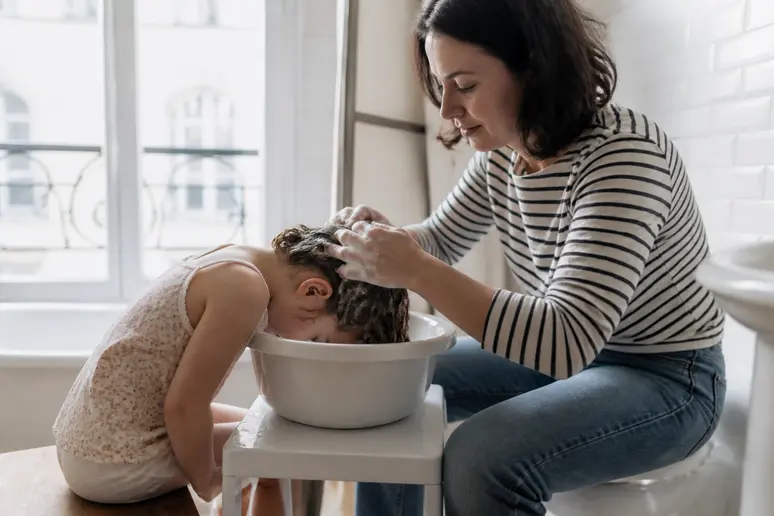 Mère lavant doucement les cheveux de sa fille à la maison, soin shampooing-enfance
