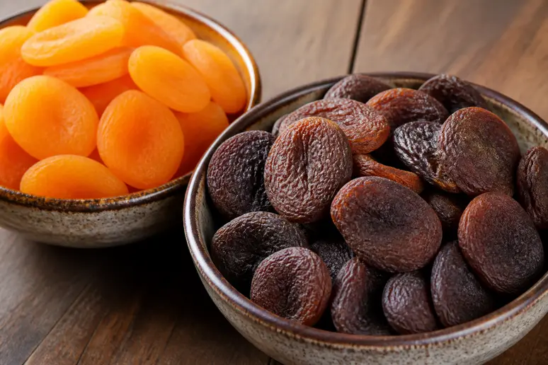 Bol de fruits secs présentant des abricots orange vif et des abricots bruns naturels