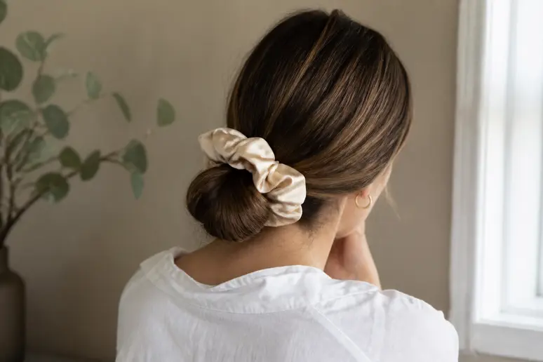 Chouchou en soie maintenant un chignon bas sur cheveux épais