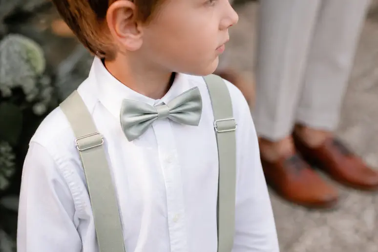 Détails des accessoires de cérémonie avec un nœud papillon et des chaussures pour un garçon d'honneur