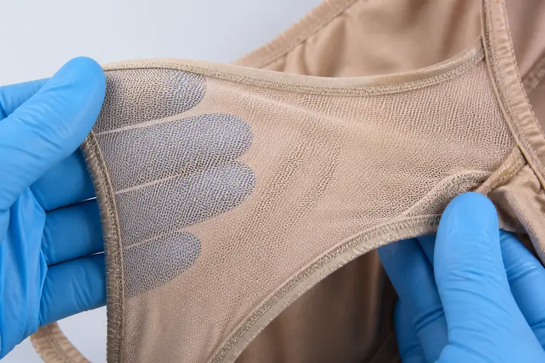 Gros plan sur la doublure intérieure en power mesh d'un maillot de bain, offrant un soutien ciblé.