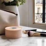Rouleau de ruban adhésif cosmétique et pinceaux de maquillage posés sur une table pour apprendre comment poser body tape.