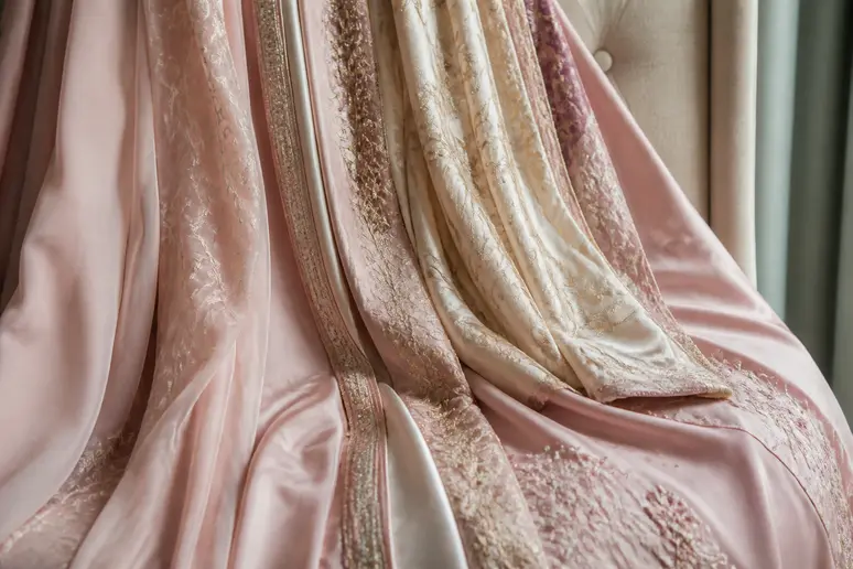 Détail de tissus soyeux et de teintes pastel pour une robe de cérémonie chic