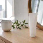 Embryolisse Lait-Crème Concentré avis posé sur une table en bois clair avec un ramequin blanc
