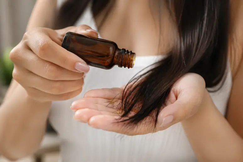 Application d'une noisette d'huile de batana sur les pointes des cheveux.