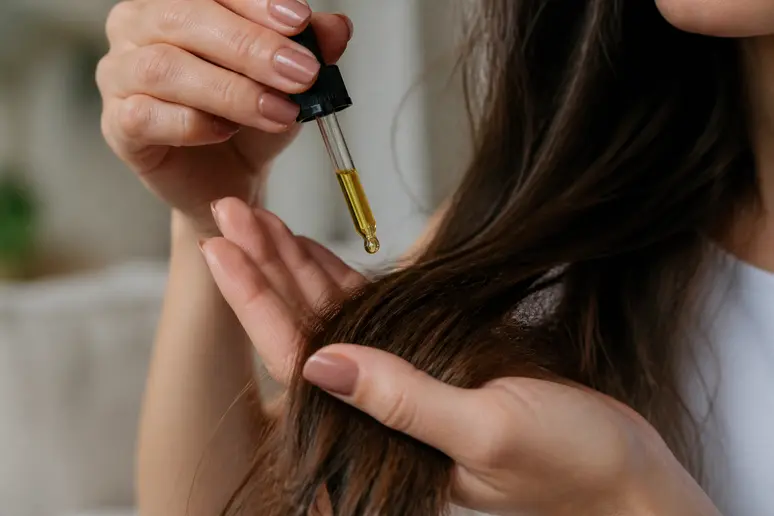 Application d'un soin capillaire nourrissant sur les longueurs et pointes de cheveux.