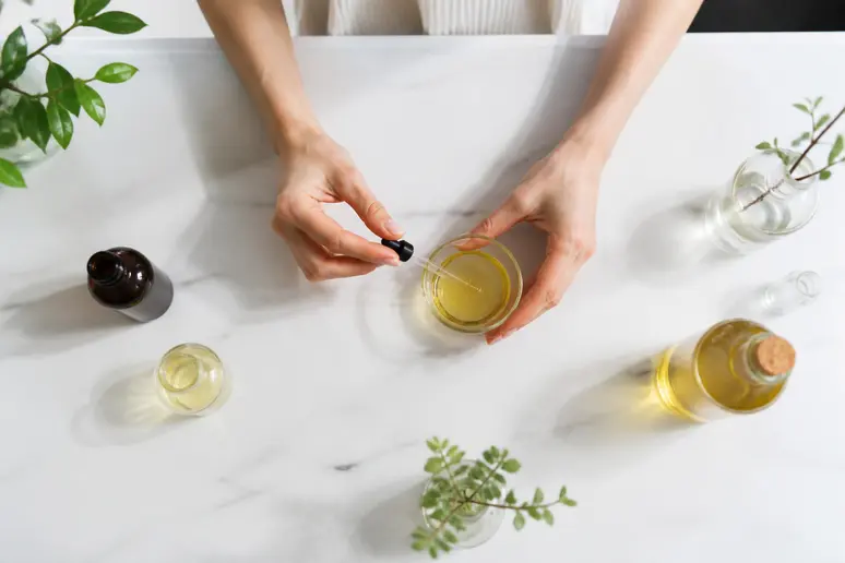 Mélange d'huiles végétales pour soins capillaires dans un petit bol en verre.