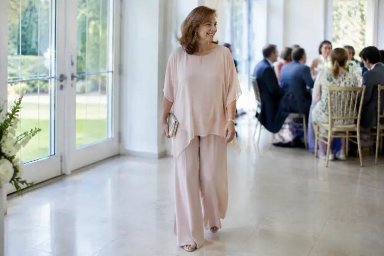 Femme mûre élégante portant un tailleur pantalon fluide en mousseline lors d'une cérémonie de mariage