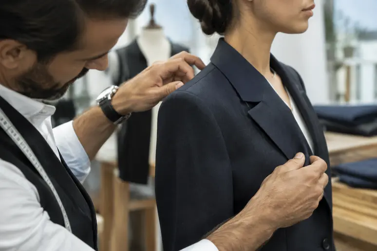 Ajustement minutieux des épaules et de la taille d'une veste de tailleur par un couturier